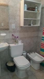 a bathroom with a white toilet and a sink at Casa de Campo LA CANTERA in Federación