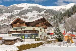 dom w śniegu z górami w tle w obiekcie Gästehaus Gratz - inklusive Eintritt in die Alpentherme w mieście Dorfgastein