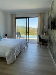 - une chambre avec un lit et un bureau avec vue dans l'établissement Villa neuve avec grande piscine chauffée vue mer, à Conca