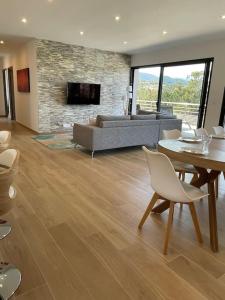 - un salon avec un canapé, une table et des chaises dans l'établissement Villa neuve avec grande piscine chauffée vue mer, à Conca