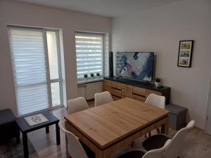 un soggiorno con tavolo in legno e TV di Apartament River Skierniewice a Skierniewice