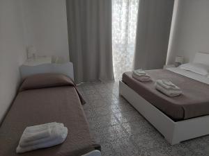 1 dormitorio con 2 camas y toallas. en Domus Dejanas - Appartamento 180 mq a Quartu, en Quartu SantʼElena