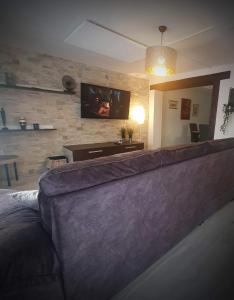 a living room with a couch and a tv at Apartman Incerum in Požega