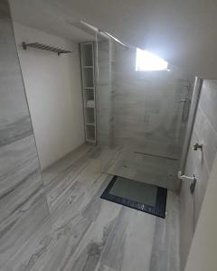 a bathroom with a shower with a glass door at Apartman Incerum in Požega