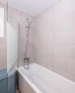 Happy Stay Apartment - Halefka Court في لارنكا: حمام أبيض مع حوض استحمام ودش