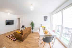 a living room with a table and a couch at Paris & DisneyLand - 2min From Train Station - Free Private Parking in Villiers-sur-Marne