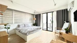 - une chambre avec un lit et une grande fenêtre dans l'établissement The Hive Homestay, à Hanoï