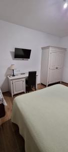 a bedroom with a bed and a desk and a tv at Villa Sofia Eden & Spa in Gaiole in Chianti