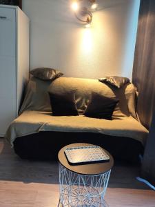 uma cama com um banco com uma mesa em frente em Studio pied des pistes em Villard-de-Lans