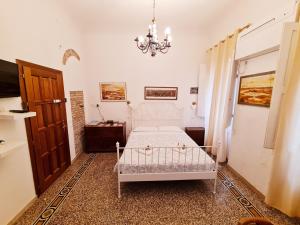 sypialnia z białym łóżkiem i żyrandolem w obiekcie Florence Signoria Apartment we Florencji