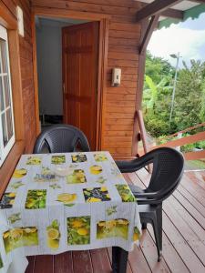 a table with a table cloth with bananas on it on a porch at Habitations Amédée in Bouillante