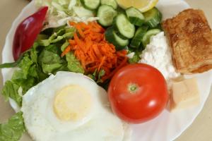a plate of food with an egg and a salad at El Mul Golan Kibbutz Country Lodging in Shaar Hagolan