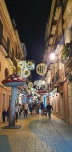 a group of people walking down a street at night at Apartamentos Plaza in Alicante