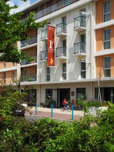 a person riding a bike in front of a building at Villa Val Senart 1ere Avenue in Quincy-sous-Sénart