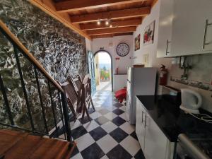 a kitchen with a staircase leading to a kitchen with a counter top at Harbour House in Paul do Mar