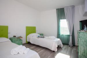 Pokój z 2 łóżkami w kolorze zielonym i białym w obiekcie B&B da Baba w mieście Ghizzano