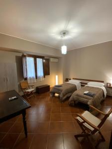 a bedroom with two beds and a table and chairs at Villa Franca in Reggio Calabria