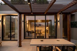 a dining room with a wooden pergola and a table at ZeusCave in Georgioupolis