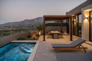 a house with a swimming pool and a patio with a table at ZeusCave in Georgioupolis