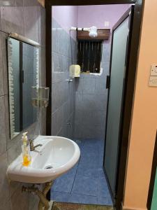 a bathroom with a white sink and a shower at Barizi Cottage in Mombasa