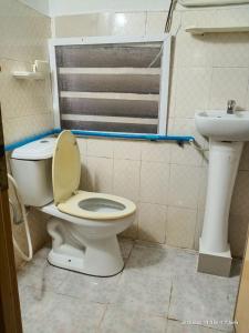 Silver Dolphin Guesthouse & Restaurant في كراتي: حمام مع مرحاض ومغسلة