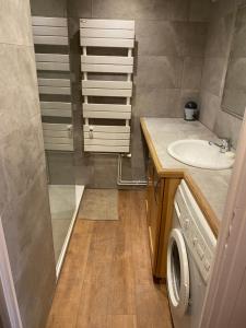 een badkamer met een wastafel en een wasmachine bij Appartement plein sud, au pied des pistes, vue imprenable in Huez