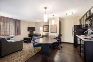 uma sala de estar com mesa e cadeiras num quarto de hotel em Sonesta Simply Suites Atlanta Gwinnett Place em Duluth