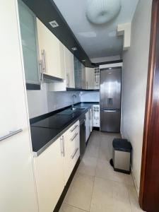a kitchen with white cabinets and a stainless steel refrigerator at Casa Emma in Playa Honda