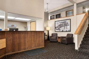 a lobby with a reception desk and two chairs at Super 8 by Wyndham Lincoln North in Lincoln