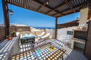 um pátio com uma mesa e cadeiras no telhado em Arhontariki Luxury Apartment em Panormos - Rethymno
