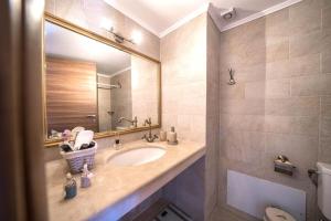 a bathroom with a sink and a mirror at Arhontariki Luxury Apartment in Panormos Rethymno +37 photos