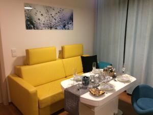 a living room with a yellow couch and a table at All about the Lake in Staré Splavy