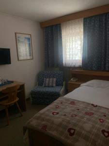 una habitación de hotel con una cama y una silla en Hotel Cime Bianche, en Breuil-Cervinia
