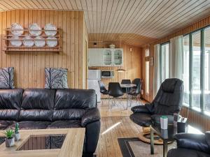 uma sala de estar com um sofá de couro e cadeiras em 6 person holiday home in Dannemare em Dannemare
