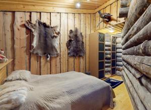 a bedroom with a bed and a wall with logs at Katasijan Villa in Salla
