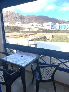 a table and chairs on a balcony with a view at APARTAMENTO AZUL in Órzola