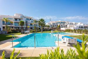 basen z 2 krzesłami i niektóre budynki w obiekcie Penthouse Lord of Mijas , Sea View 6P, Casa Banderas, D23A w mieście La Cala de Mijas