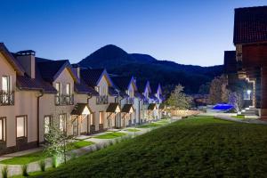 une rangée de maisons avec une pelouse verte devant dans l'établissement Apartel Shayan, à Shayan