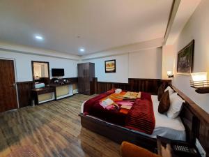 a bedroom with a bed and a desk in a room at Hotel Golden Sunrise & Spa in Pelling