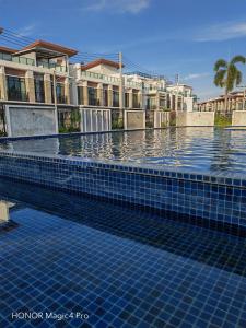 a swimming pool with blue tiles on top of it at Pat Holiday Home in Cha Am