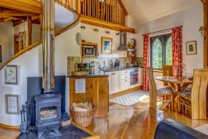een keuken met een houtkachel in een kamer bij Kinlochlaich Tree House in Appin