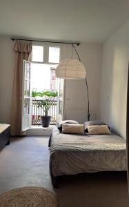 ein Schlafzimmer mit einem großen Bett und einem großen Fenster in der Unterkunft Grand Studio Luxe in Sète