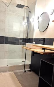 ein Bad mit einer Dusche, einem Waschbecken und einem Spiegel in der Unterkunft Grand Studio Luxe in Sète