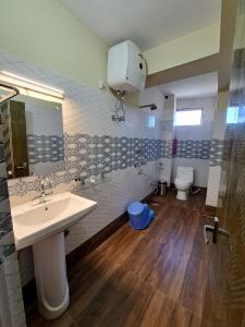 a bathroom with a sink and a toilet at Hotel Golden Sunrise & Spa in Pelling