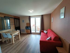 a living room with a red couch and a table at Fleurs des Alpes in Les Déserts