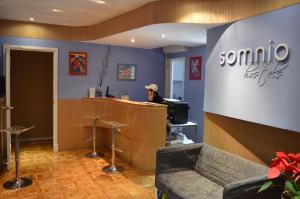 a man sitting at the counter of a somo coffee shop at Somnio Hostels in Barcelona