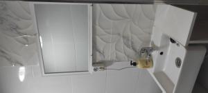 Casa Blanca 48 في أليكانتي: خزانة بيضاء في الحمام مع مرآة