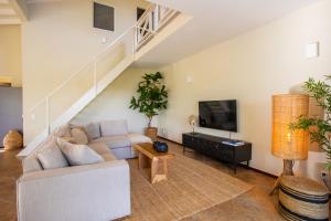 a living room with a couch and a tv at Tropicana Palm Penthouse Jan Thiel, Willemstad Curacao in Jan Thiel