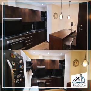 a kitchen with wooden cabinets and a counter top at Apto en Excelente Zona con Gym Sauna y Jacuzzi in Santa Cruz de la Sierra