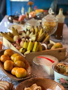 a table topped with lots of different types of fruits and vegetables at Reduto das Artes Hostel pousada in Casa Branca